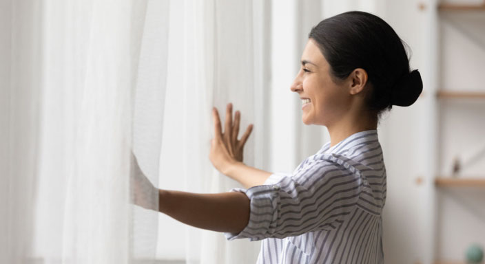 Younger woman happily looking out window