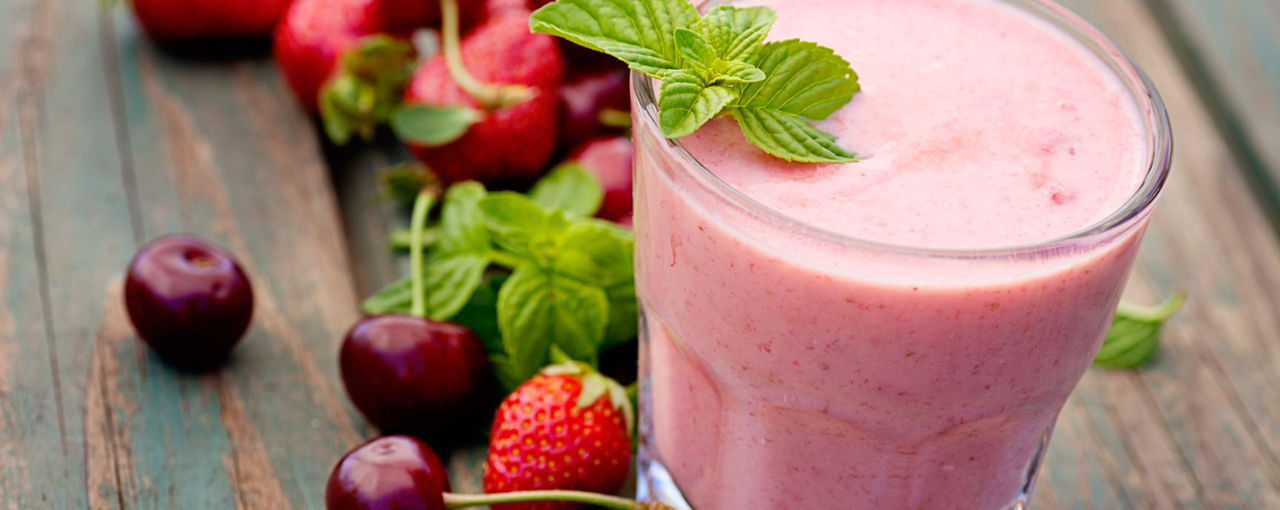 Pink smoothie next to fruit Pink smoothie next to fruit