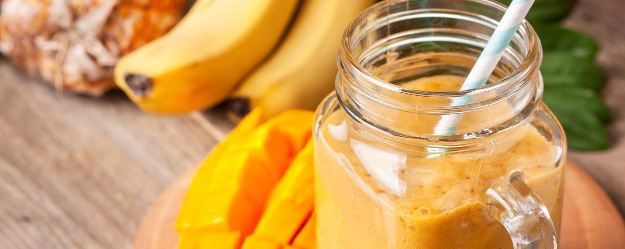 Orange smoothie next to fruit Orange smoothie next to fruit
