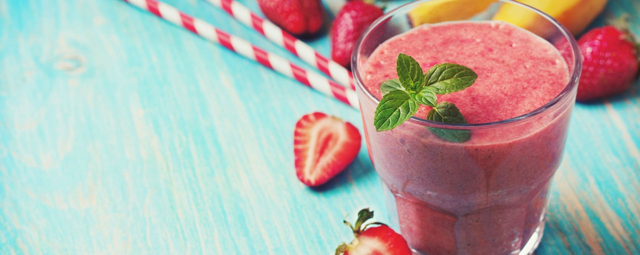 Red smoothie next to fruit Red smoothie next to fruit